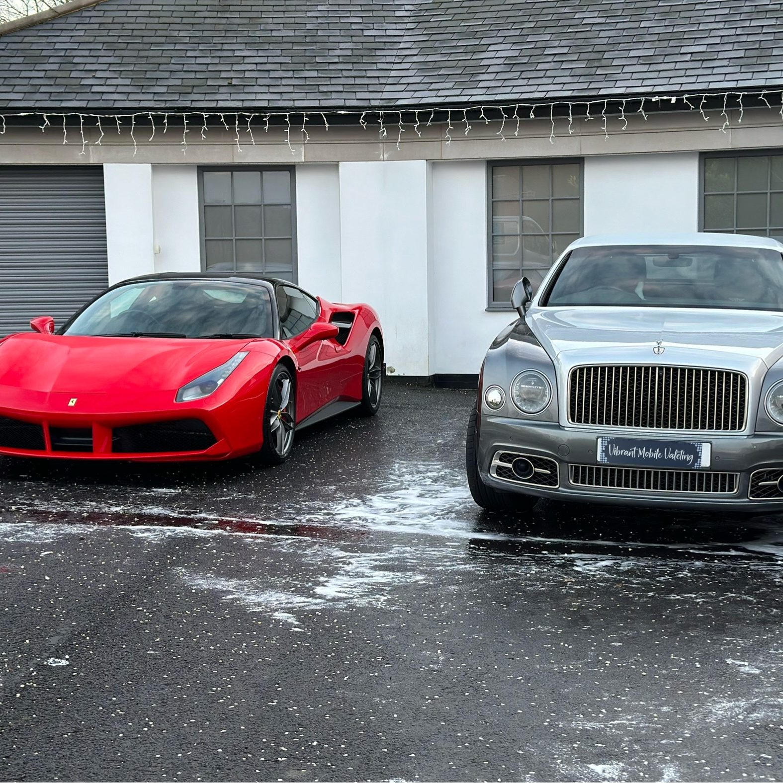 Red Ferrari and silver Rolls-Royce after professional vehicle detailing